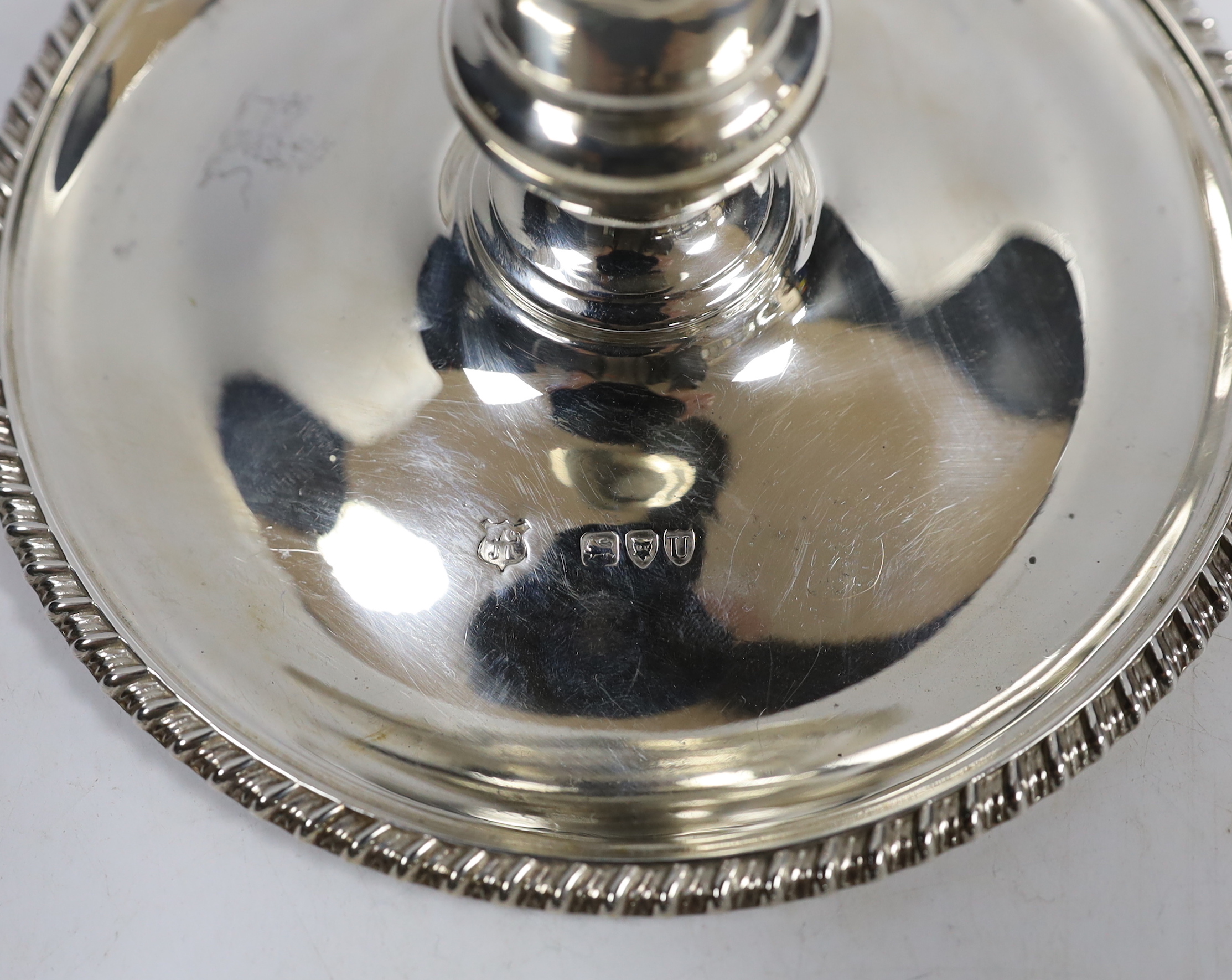 A late Victorian silver chamberstick and matching extinguisher, by Goldsmiths & Silversmiths, London, 1895, with gadrooned border, base diameter 15cm, 9.7oz.
